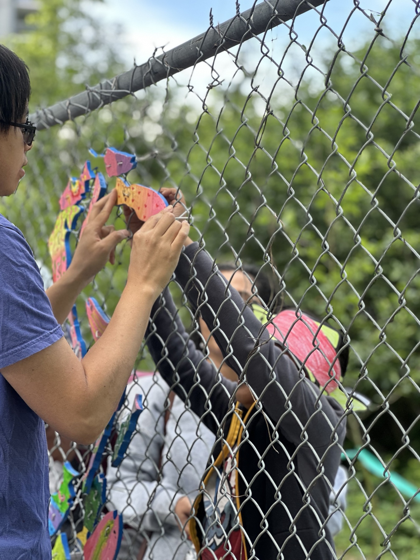 Participant attaching a colorful paper fish to a community display during World Fish Migration Day